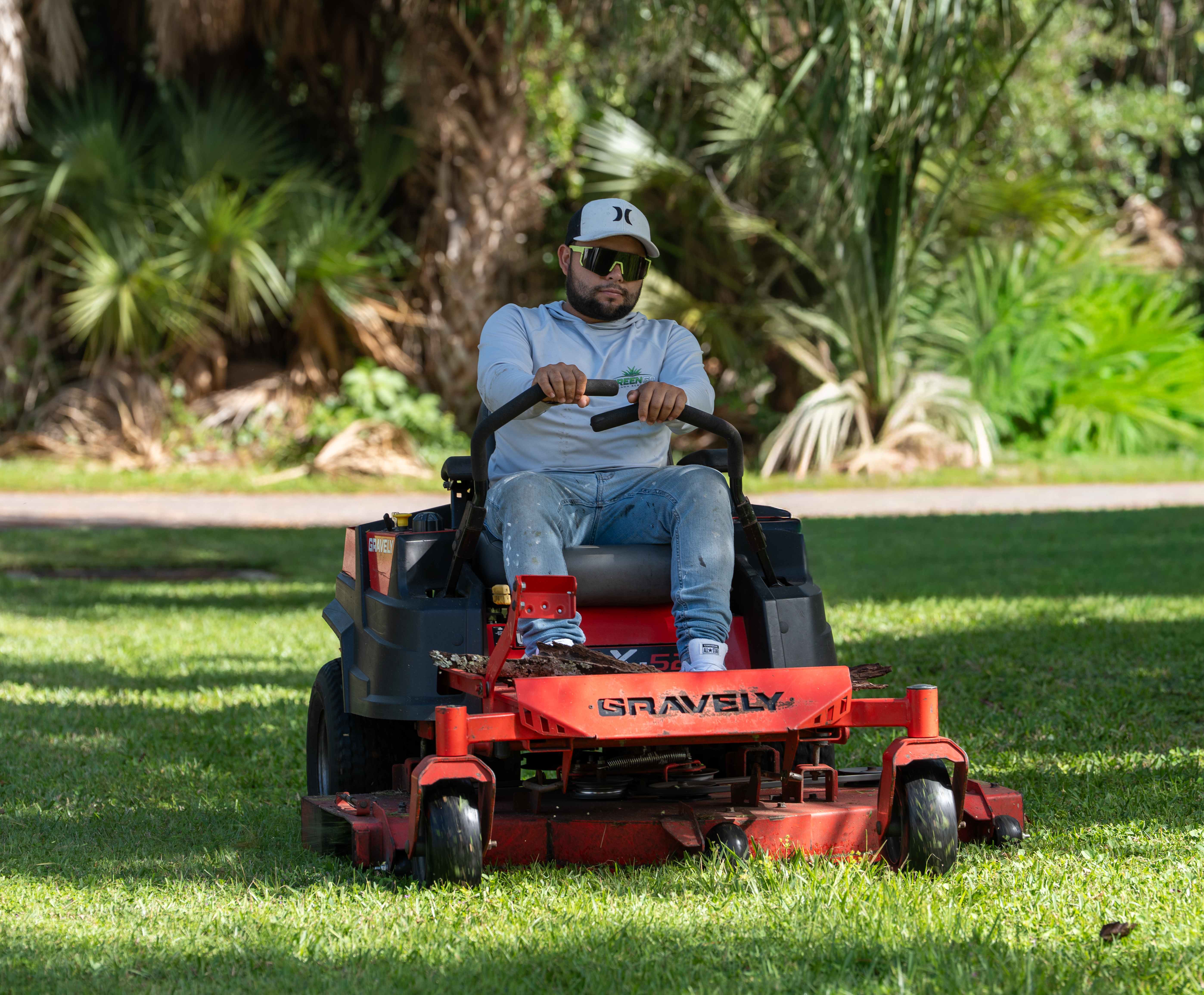 Lawn care worker mowing a freshly striped Florida lawn
